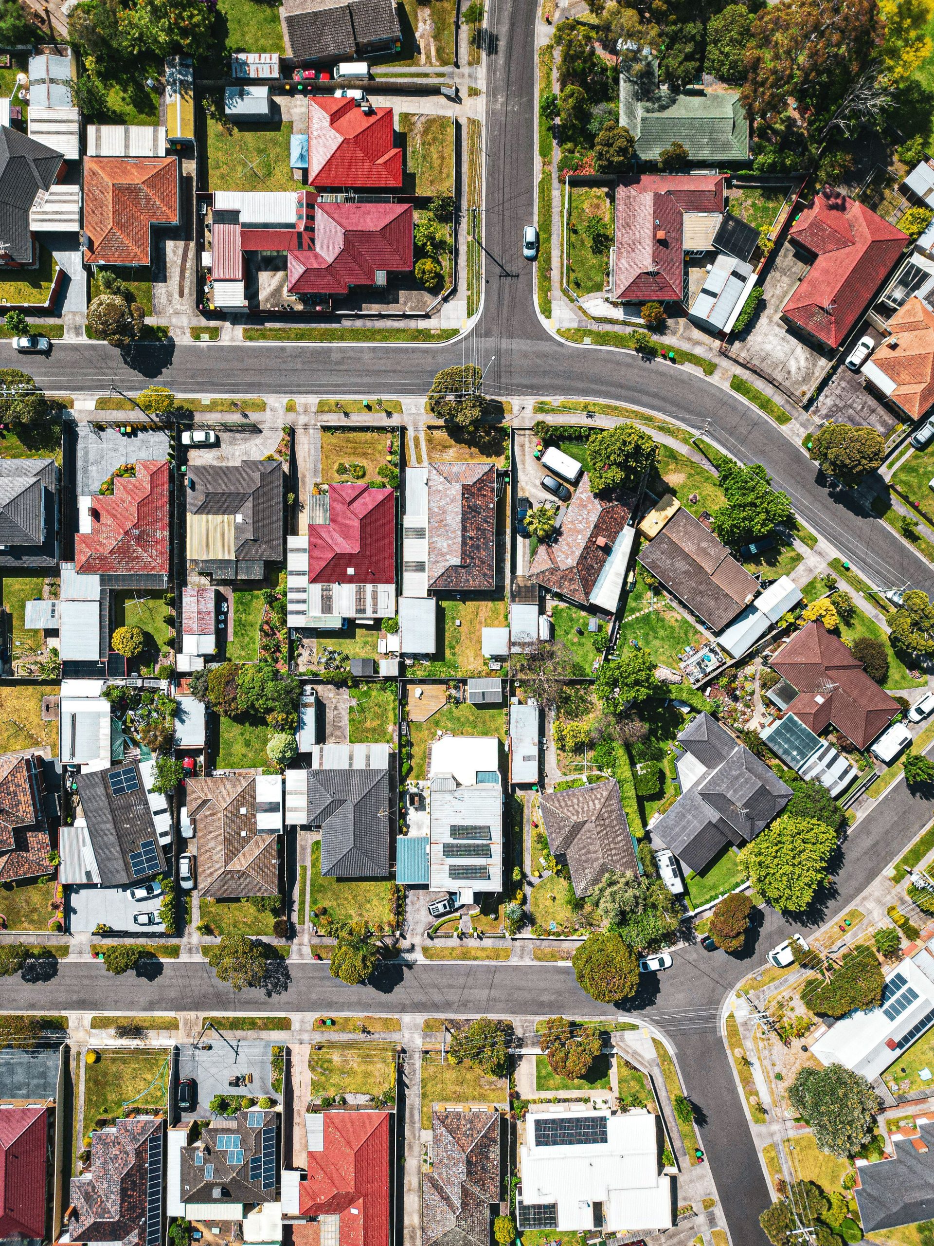 Drone shot of a colorful Melbourne suburb with vibrant rooftops and streets on a sunny day.